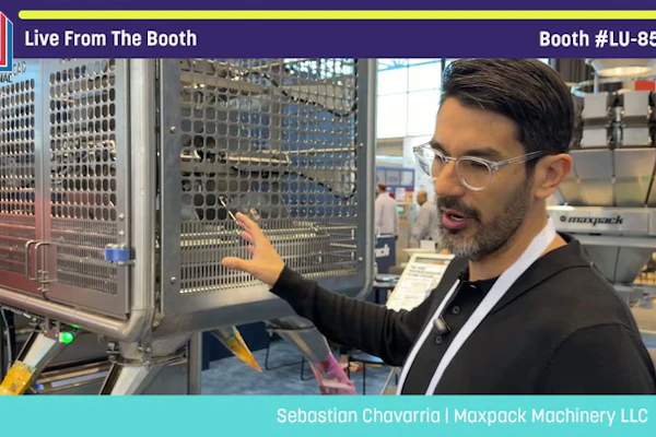Man presenting industrial packaging machinery at Pack Expo booth LU-8547