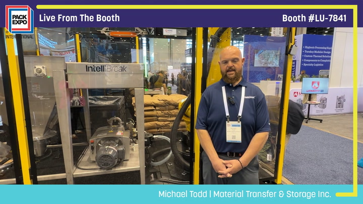 Man in blue shirt standing at Pack Expo booth LU-7841 with IntelliBreak material transfer equipment on display