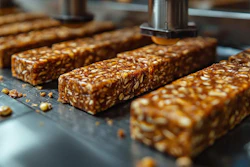 Rows of granola bars with nuts and seeds on a production line conveyor
