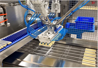 Industrial packaging machinery with blue pneumatic tubes and conveyor system processing products on assembly line