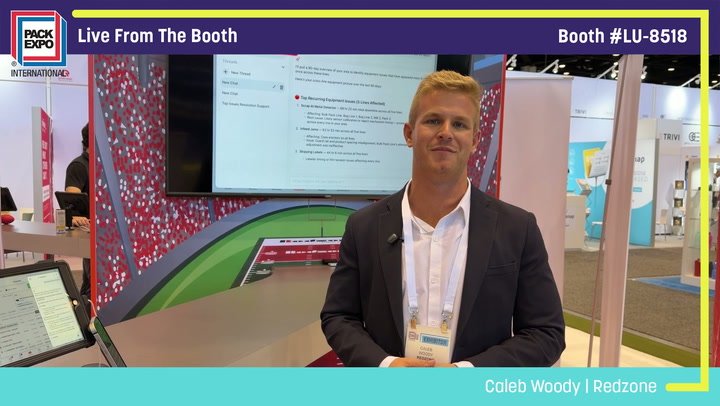 Professional man in blazer presenting at Pack Expo booth with display screen and red patterned backdrop