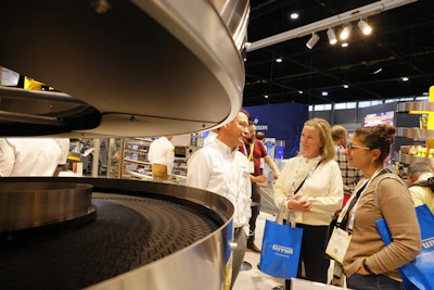 Professionals discussing industrial equipment at a trade show exhibition with branded merchandise visible