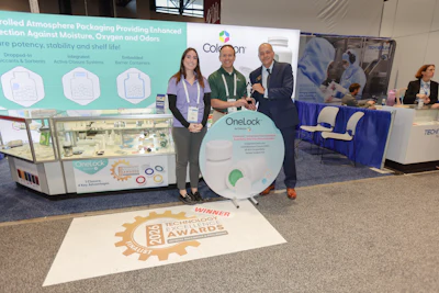Three professionals pose at a trade show booth displaying OneLock packaging technology and Tech Briefs Awards winner signage.