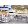 Industrial facility showroom displaying food processing equipment with blue and white branded signage